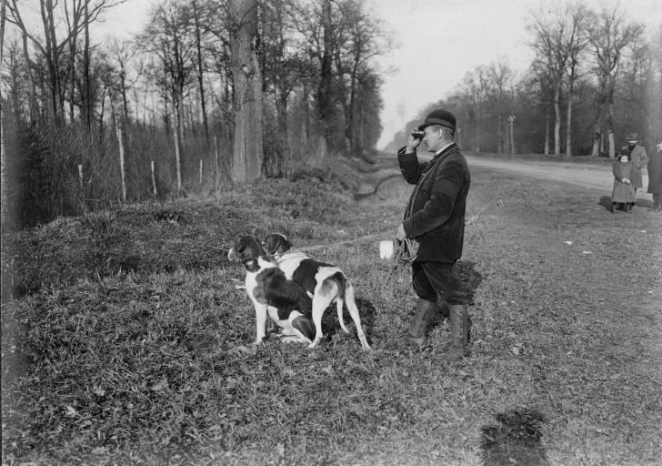 Photographie extraite d'un album de 56 photographies : équipages Chantilly et Par Monts et Vallons. Veneur et ses chiens