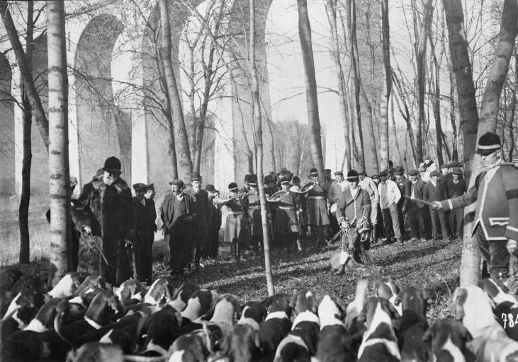Photographie extraite d'un album de 56 photographies : équipages Chantilly et Par Monts et Vallons. Piqueux présentant la nappe lors de la curée ; duc de Chartres à gauche