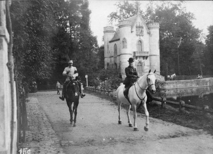 Photographie extraite d'un album de 56 photographies : équipages Chantilly et Par Monts et Vallons. Un officier et la duchesse de Chartres devant le château de la Reine-Blanche aux étangs de Commelles
