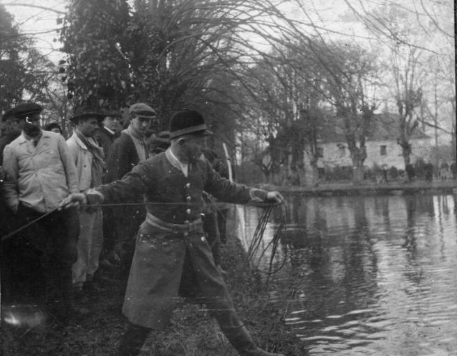 Photographie extraite d'un album de 56 photographies : équipages Chantilly et Par Monts et Vallons. Piqueux s'affairant lors d'un bat l'eau