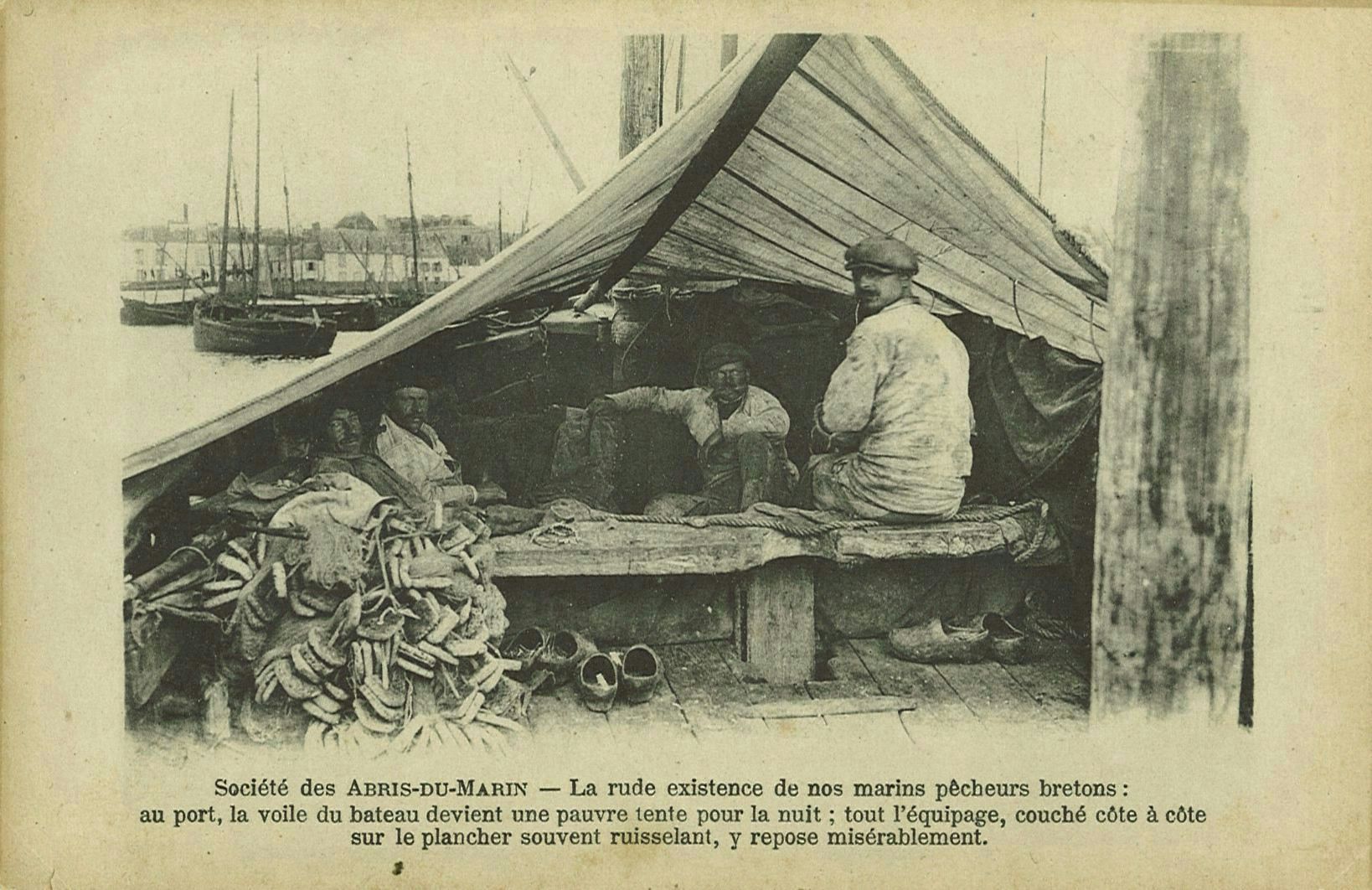 La rude existence de nos marins pêcheurs bretons : au port la voile du bateau devient une pauvre tente pour la nuit. tout l'équipage couché côte à côte sur le plancher souvent ruisselant y repose