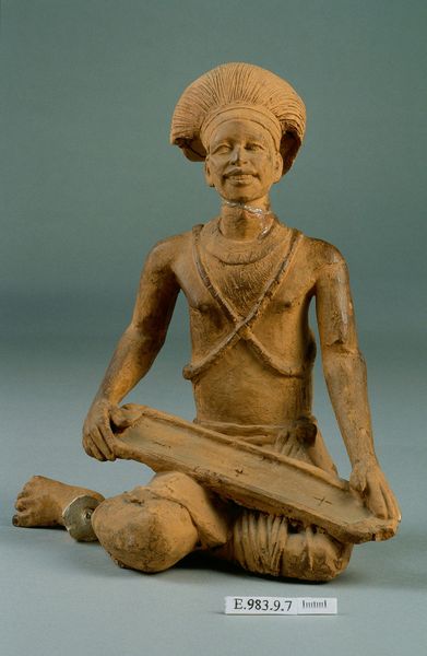 Homme agenouillé jouant de la cithare