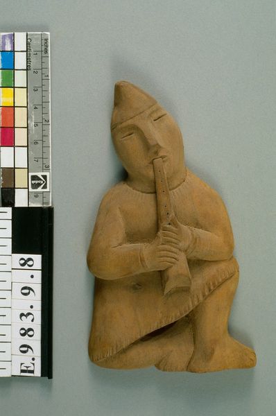 Plaque en bois réprésentant un homme accroupi jouant du hautbois turc ?